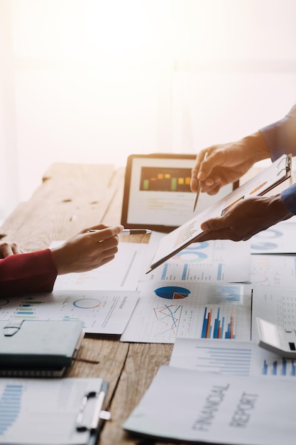 Group of confident business people point to graphs and charts to analyze market data balance sheet account net profit to plan new sales strategies to increase production capacity