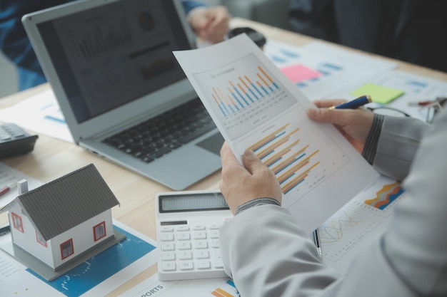 Group of confident business people point to graphs and charts to analyze market data balance sheet account net profit to plan new sales strategies to increase production capacity