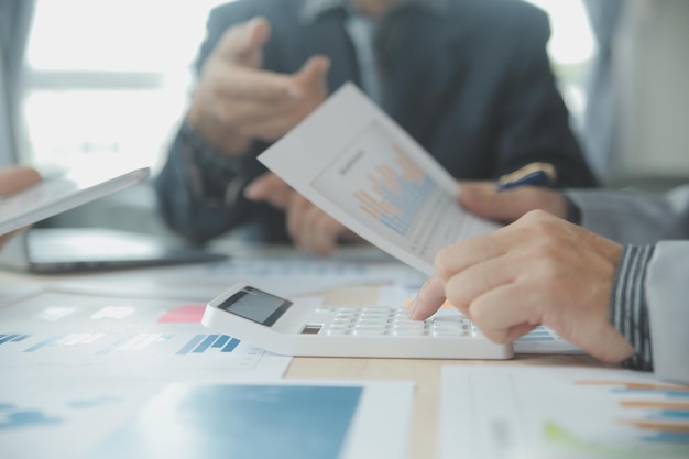 Group of confident business people point to graphs and charts to analyze market data balance sheet account net profit to plan new sales strategies to increase production capacity