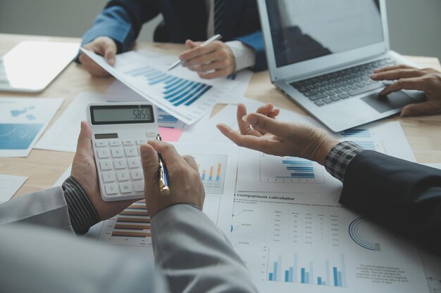 Group of confident business people point to graphs and charts to analyze market data balance sheet account net profit to plan new sales strategies to increase production capacity