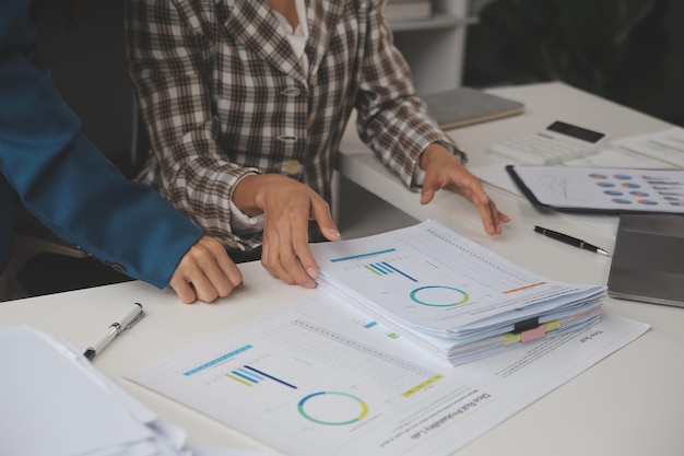 Photo group of confident business people point to graphs and charts to analyze market data balance sheet account net profit to plan new sales strategies to increase production capacity