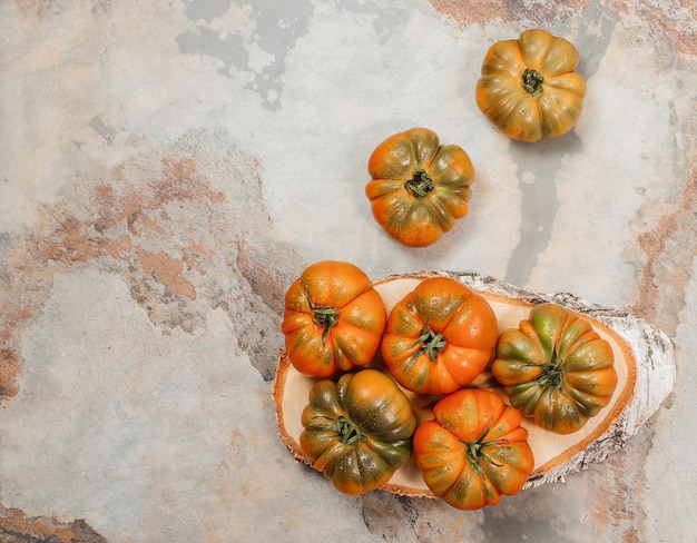 A group of Costoluto big tomatoes on a brown wooden background rustic concept space for text