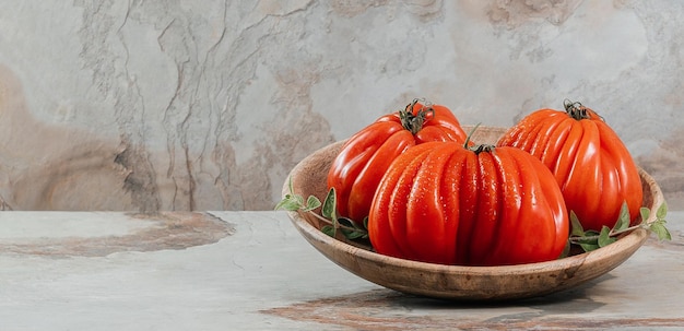 A group of Costoluto big tomatoes with oregano on a brown background space for text