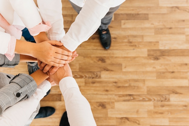 Group of coworkers putting hands together