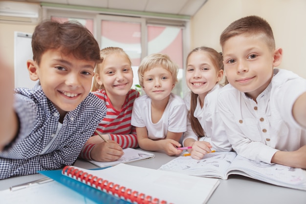 Group of cute little kids drawing together in art class