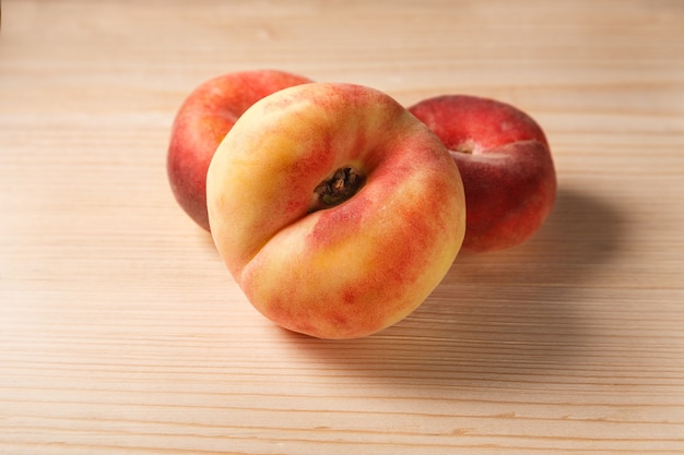 Group of delicious sweet flat donut peaches on old wooden table