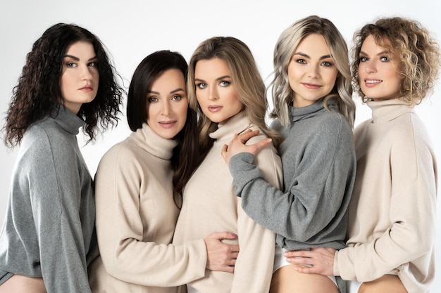 Group of different women wearing turtleneck jumpers on gray background