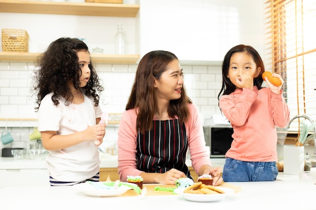 Group of Diverse Family Asian and Arab Preschool African Arab kid person make Cake cooking in kitchen Mother prepare decoration pretty with fun educate on snack Cream mess all over face copy space