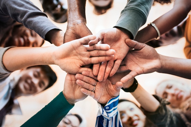 Group of diverse people stacking hands in the middle