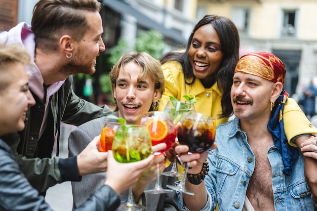 Group of diverse people toasting with beverage happy friends celebrating and drinking cocktails at restaurant lgbt social inclusion concept