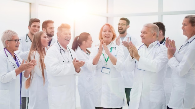 Group of diverse smiling doctors applauding together.