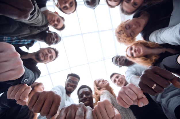 Group of diverse young people joining their hands in a ring