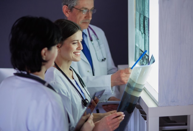 Group of doctors examining x-rays in a clinic, thinking of a diagnosis