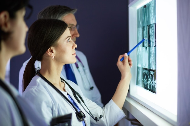 Group of doctors examining xrays in a clinic thinking of a diagnosis