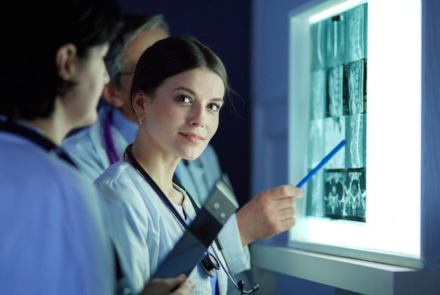 Group of doctors examining xrays in a clinic thinking of a diagnosis