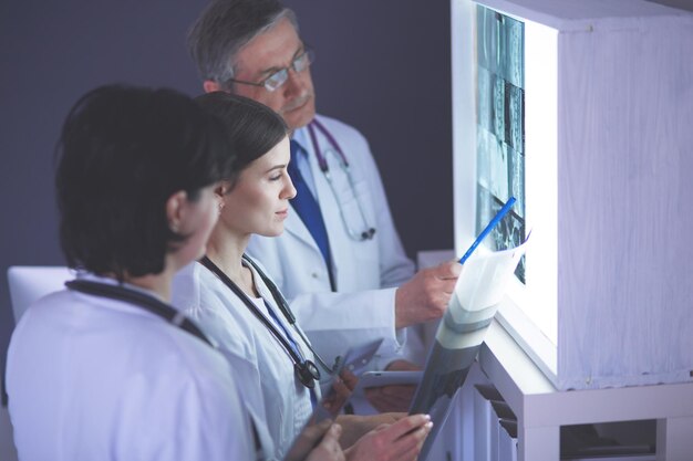 Group of doctors examining xrays in a clinic thinking of a diagnosis