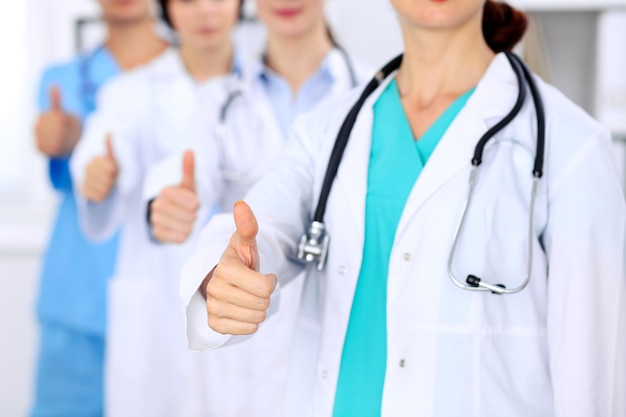 Group of doctors showing OK or approval sign with thumb up. High level and quality medical service, best treatment and patient care concept.