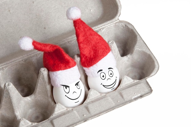 Group of eggs in toy christmas hats with drawn emotions