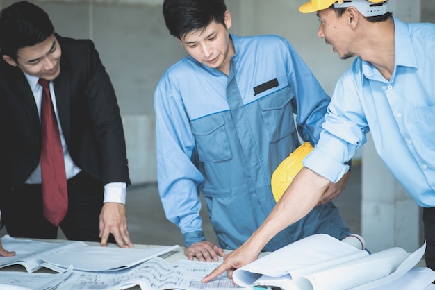 Group of engineers and architects discuss at a construction site