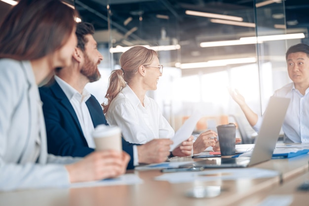 Group of executives lawyers and investors gather at the table in corporate meeting room