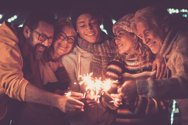 Group of family people celebrate new year outdoor lighting sparklers