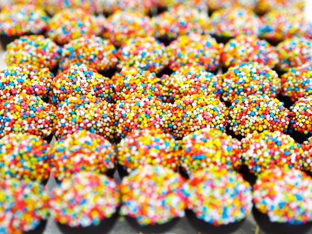 Group of fancy chocolate balls with colorful topping and sticks for party, Top view.