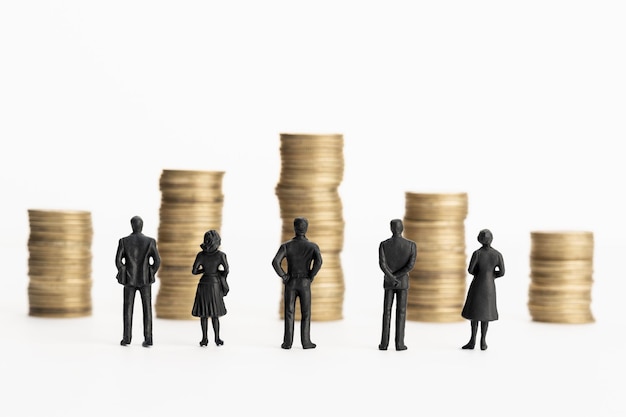 Group of figurines looking at stacks of coins