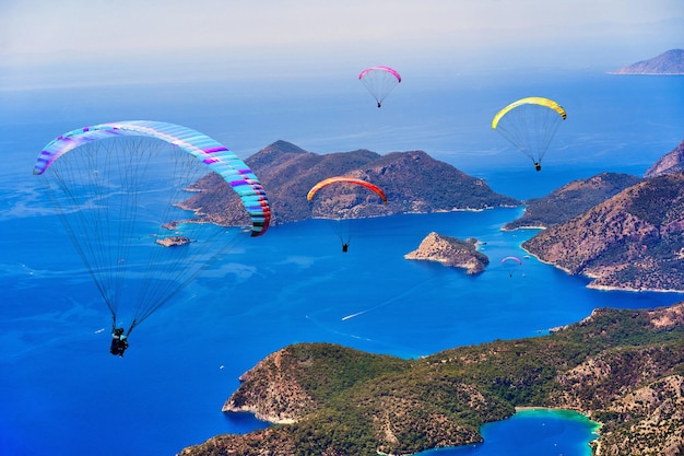 Group of flying paragliders over mountain islands in the blue sea Oludeniz Turkey