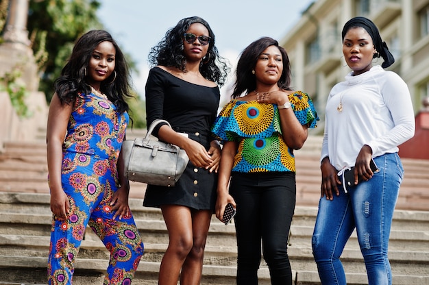 Group of four women walking at stairs of city