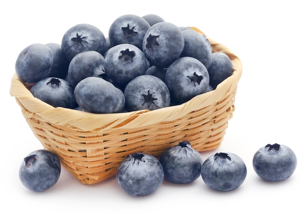 Group of fresh blueberries in a basket over white background