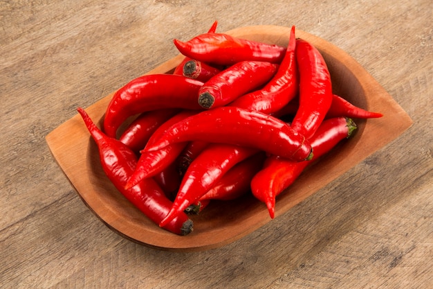 Group of fresh red hot peppers on a wooden table. Fresh peppers.