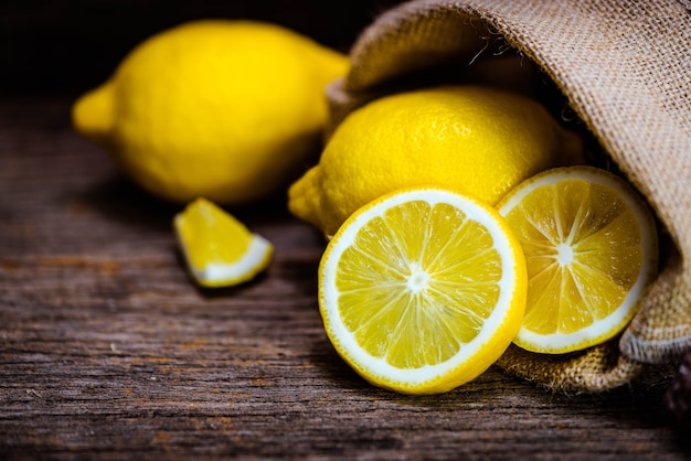 Group of fresh yellow lemon fruit on wood background with burlap