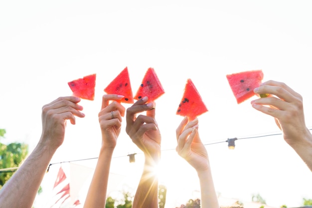 Group of friends eat fresh watermelon together