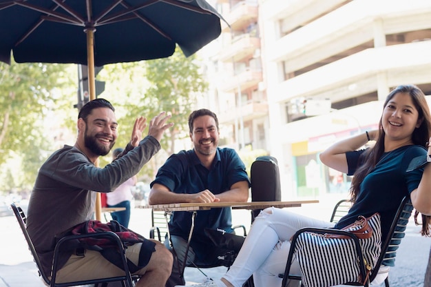 Group of friends enjoying sitting on the sidewalk in front of a fast food restaurant