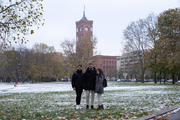 Group of friends or family in a Berlin park with the Rotes Rathaus in the background and all snowed in