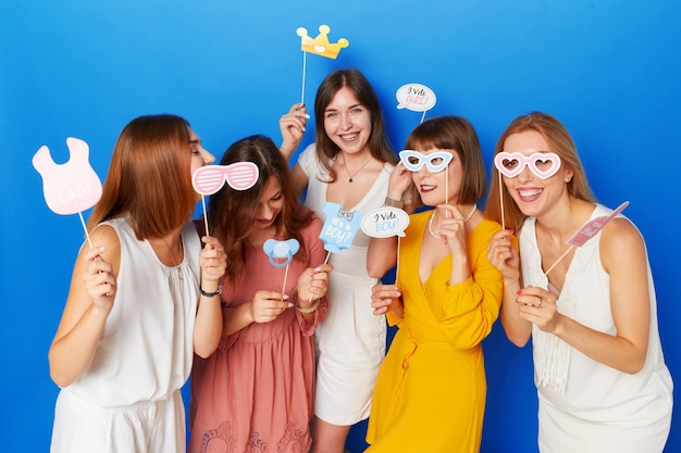 A group of friends happy to have gender reveals envent isolated blue background