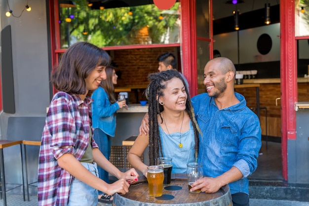 A group of friends having drinks and fun outside at a pub.