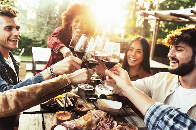 Group of friends having fun at bbq dinner in garden restaurant