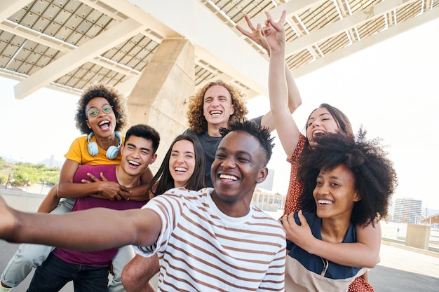 Group of friends having fun in the city young interracial students taking a selfie concept of friend