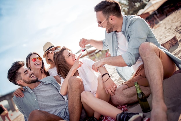 Group of friends having fun relaxing on the beach