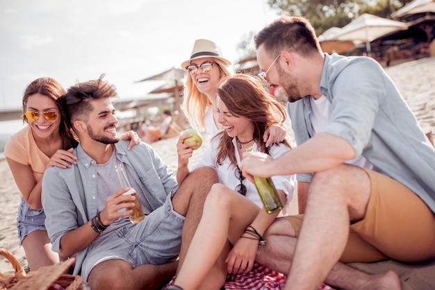 Group of friends having fun relaxing on the beach