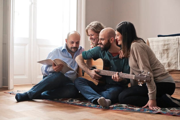 Group of friends at home play guitar