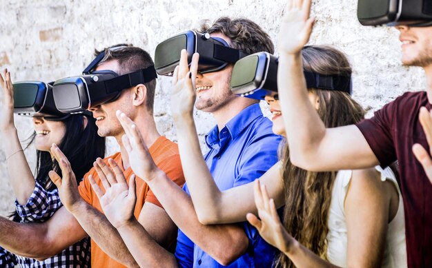 Group of friends playing on vr goggles outdoors