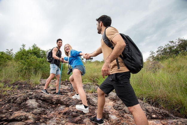 group of friends pull their hands up the mountain during the trek