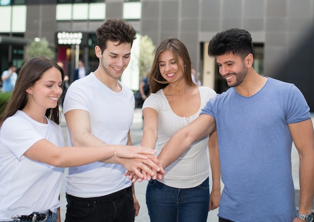 Group of friends putting their hands together, friendship concept