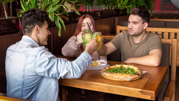 A group of friends resting in a pub. Eating, drinking, food on the table. Friendship