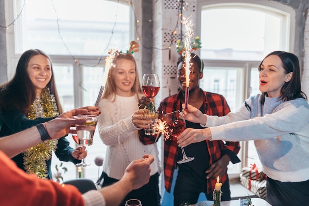 Group of friends standing together and toasting drinks.