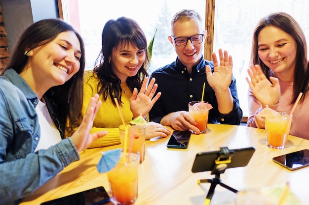 A group of friends video call and greet the other person