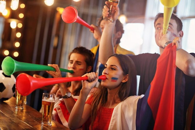 Group of friends watching soccer game in pub