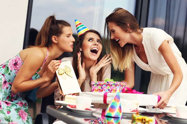 Group of friends with cake and presents celebrating birthday